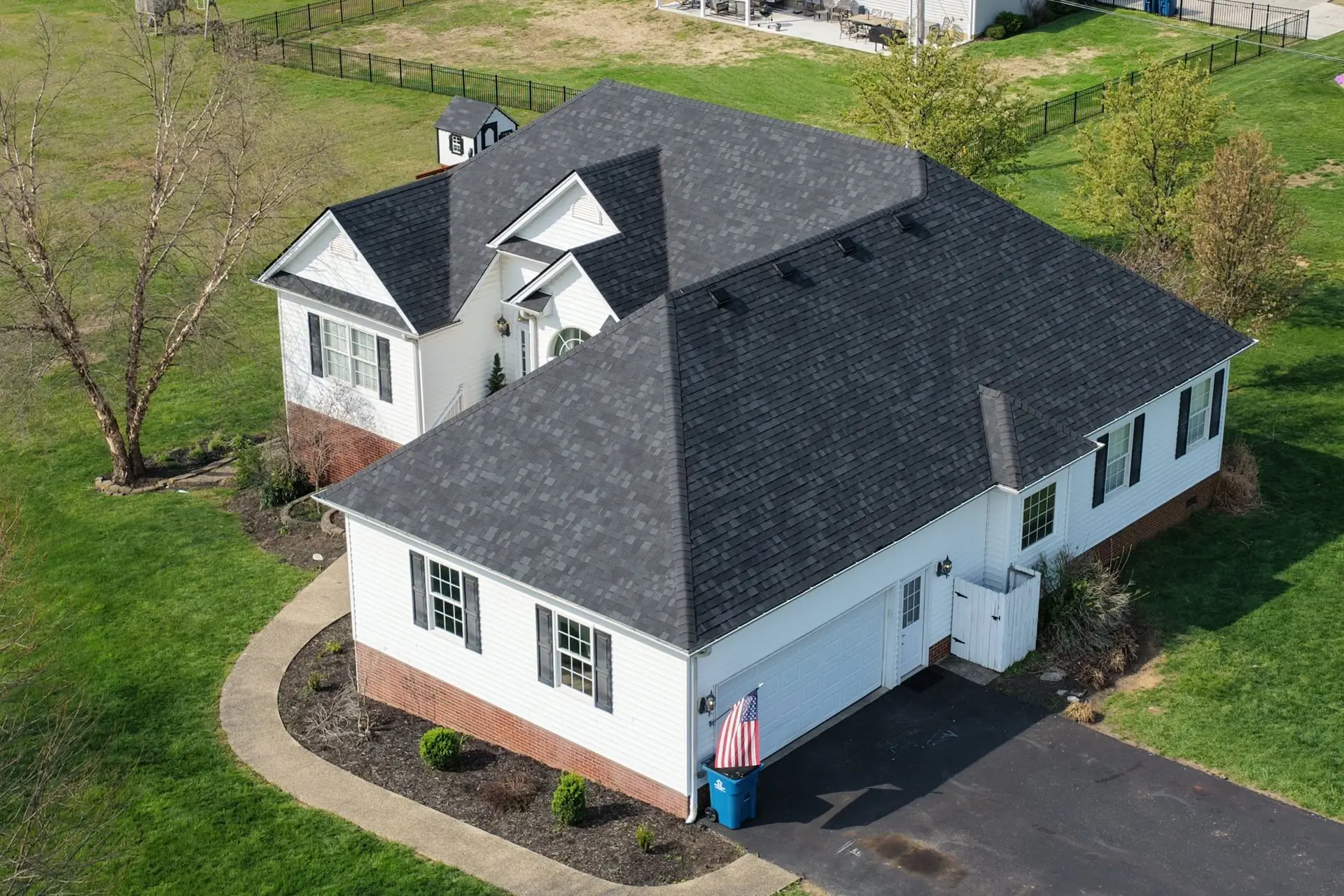 Completed residential home with architectural asphalt shingles, showcasing roofing services in Central Kentucky.